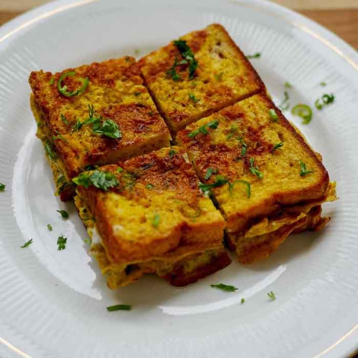Golden omelette cut into squares and garnished with herbs
